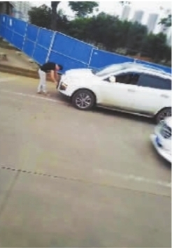 男子拿抹布套在了前车牌上。