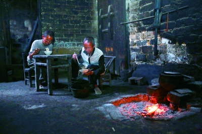 在母亲的反复教导下,孟阿香的二儿子(右)终于学会了做饭。母亲病中,就由他做饭给同样智障的哥哥和弟弟吃
