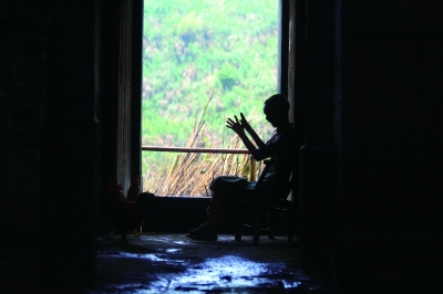 孟阿香的三儿子坐在老屋门口，不断地挥动双手，自言自语