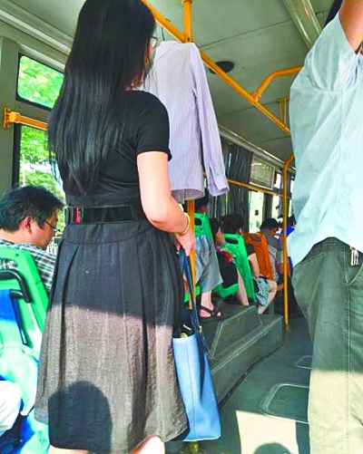 女子在公交车上晒衣服。