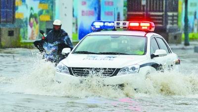 昨天，一辆警车急速行驶过园博大道宜家前渍水路段。记者金振强 摄