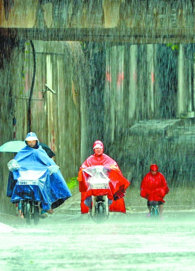 建设大道上，雨中艰难前行的路人。记者熊波 摄