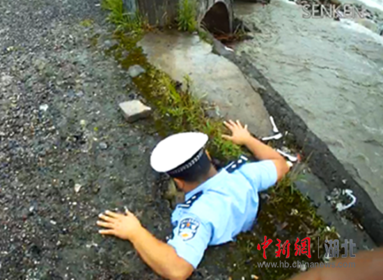 桥面坍塌，民警被卡路面决绝施救\刘勇被卡路面（视频截图）。