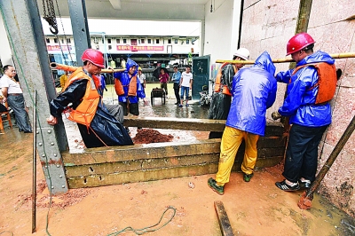 昨日中午在汉口沿江大道的6号码头闸口，码头工人正在忙着用条石和泥土封堵闸口。记者詹松 摄
