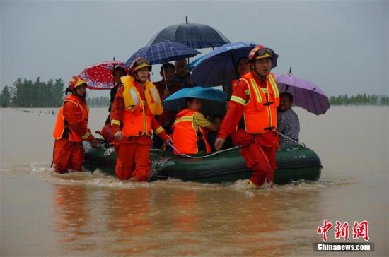 7月1日，湖北麻城遭遇特大暴雨袭击，导致该市境内多地山洪暴发、河水陡涨、民房进水、房屋倒塌、农田冲毁，公路、水利、通讯、电力等基础设施损毁严重。灾情发生后，消防、武警等多方力量展开救援。截至1日晚12时，该市共转移安置受灾人员2.3万余人。图为救援人员在麻城一村庄转移被困人员。 刘烨 摄