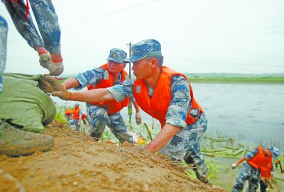 昨天，解放军某部抗洪抢险小分队正在斧头湖加固堤坝。记者杨少昆 摄