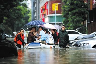 昨日，湖北武汉武昌一小区内，由于积水过深，消防官兵用橡皮艇拉着市民们一批批转移。图/视觉中国