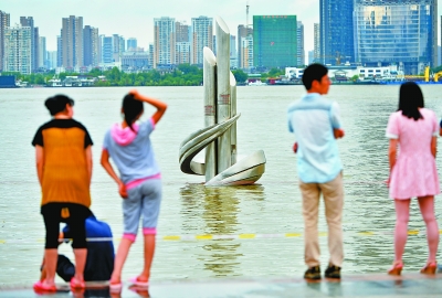 市民正在观看亲水平台上的水位标志雕塑（记者喻志勇 摄）