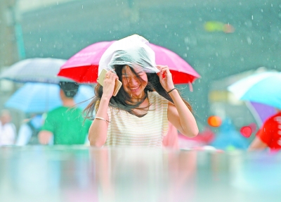 昨天，在汉口解放大道，一位女士在雨中顶着塑料袋赶路。记者金思柳 摄