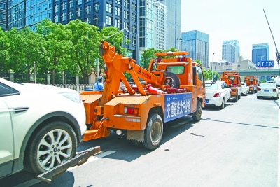 昨天，武昌公正路，3辆牵引车“组团”出动，拖走违停车辆。 通讯员徐飞 摄