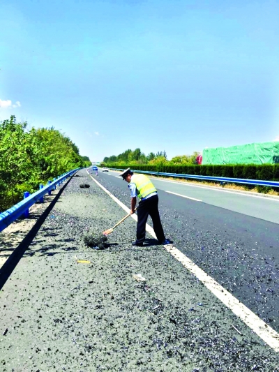 高速交警正在清理路面的铁屑  省高警襄阳大队 供图