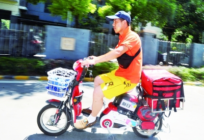 骑电动车送餐中的外卖员。记者李子云 摄