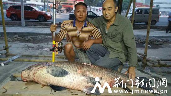 图为“寒大师”(左)和钓友与青鱼王合影留念。