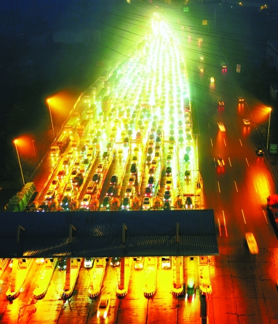 昨晚9时30分，武鄂高速公路龚家岭收费站出城车流排成长龙   记者胡九思 摄