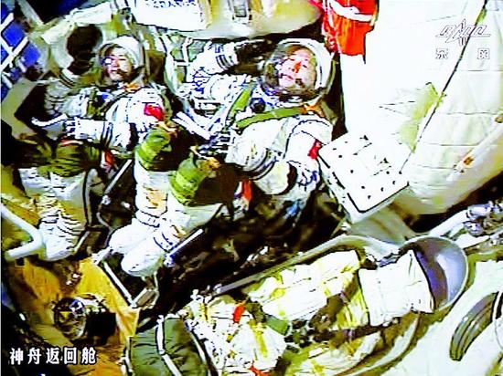 图为：17日，景海鹏（右）和陈冬在火箭发射瞬间敬军礼（屏幕截图）