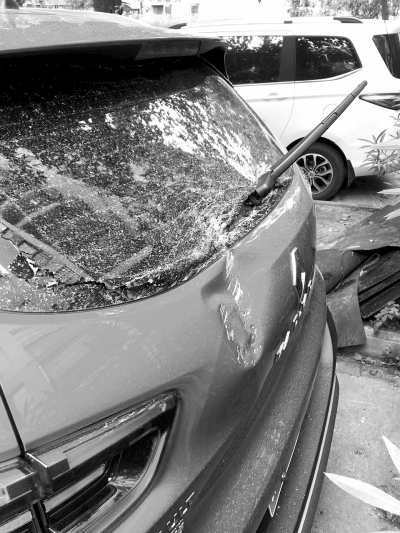 右图：轿车后挡风玻璃被砸破。