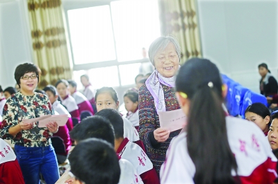 16日，蕲春县青石镇青石中学，陈静一和女儿陈翎给学生发放助学金