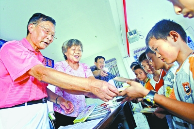 2010年9月3日，蕲春县青石镇青石中学，卢明和陈静一给孩子们发放助学金