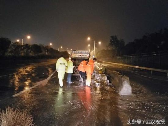 武汉三环线上大货车翻车 环卫工冒雨清理6吨水泥块