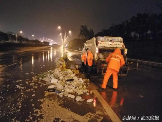 武汉三环线上大货车翻车 环卫工冒雨清理6吨水泥块