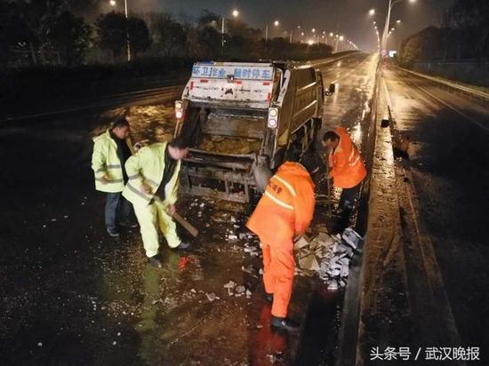 武汉三环线上大货车翻车 环卫工冒雨清理6吨水泥块