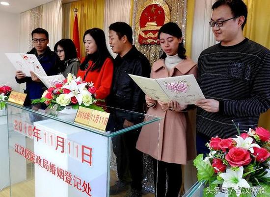 图片：在江汉区民政局婚姻登记处,有60对成熟的恋人,携手共进,走向了奔小康新生活的殿堂,喜领了结婚证,他们在一起髙声宣读了结婚誓词。 通讯员李长林 摄