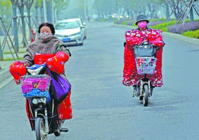昨天，武漢街頭，兩位女士著冬裝騎電動車。記者胡偉鳴 攝