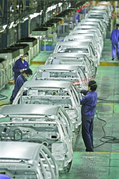 武汉神龙汽车有限公司总装生产线上，工作人员正在忙碌。记者陈卓 摄