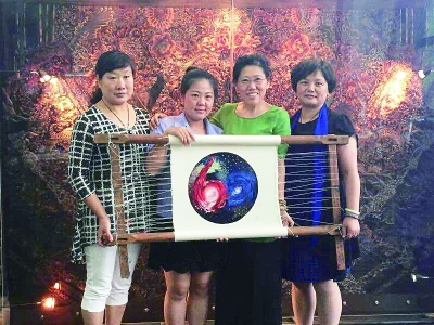 王燕（右一）和三位大师展示汉绣“星云之梦”。记者杨佳峰 摄