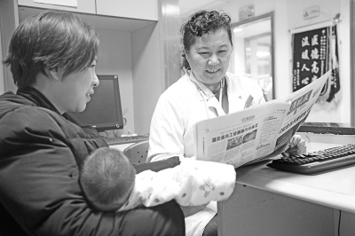 昨天,张雯女士特意带一份武汉晚报送给省妇幼保健院许慧医生(右)。通讯员温红蕾 摄