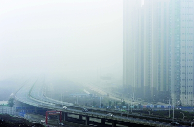 昨天，江城遭遇雾霾笼罩，城市建筑物在雾霾中若隐若现。记者李子云 摄