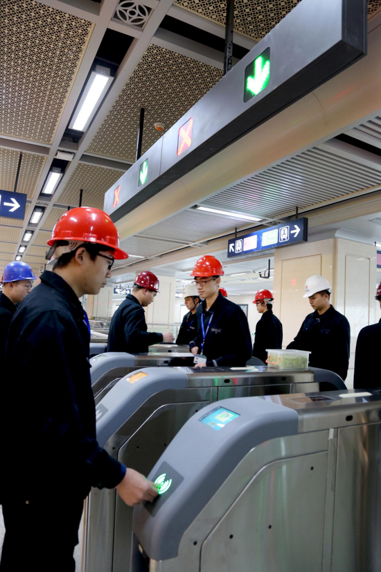 图为工作人员在6号线江汉路站对闸机进行压力测试