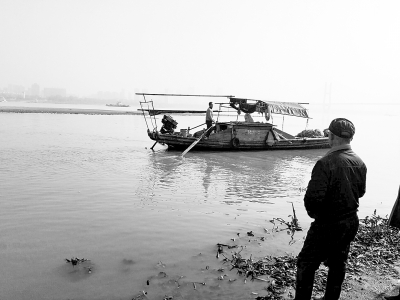 木船在江中打捞溺水老人。记者李爱华 摄