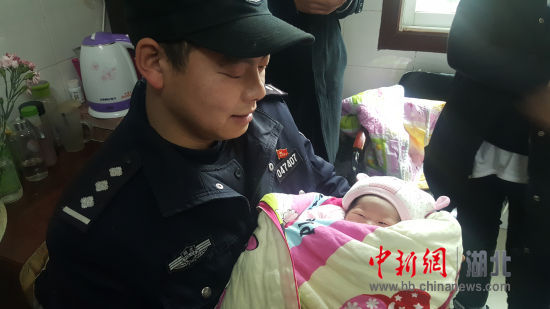 图四为民警杨清抱着女婴