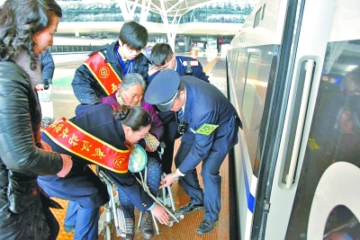 李玉兰在铁路工作人员帮助下上车 通讯员 陈端 摄