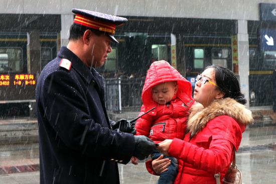 旅客邓巍向十堰车站客运值班员黄涛求助。张玲莉 摄