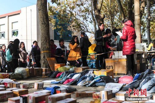 资料图：2016年11月11日，济南一高校物流配送站里快件摆满地，女大学生们排长队领取网购商品。（中新社记者 张勇 摄）