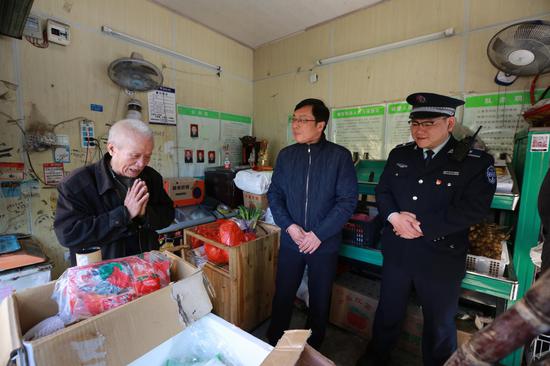 武汉市城管委主任张军和胡毅峰看望水果店主家人