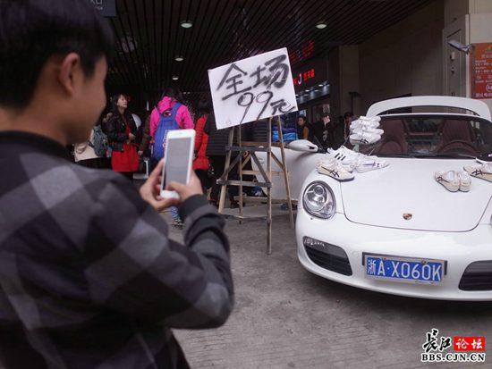 江汉路一男子在豪华跑车上摆摊卖鞋 引众人围观