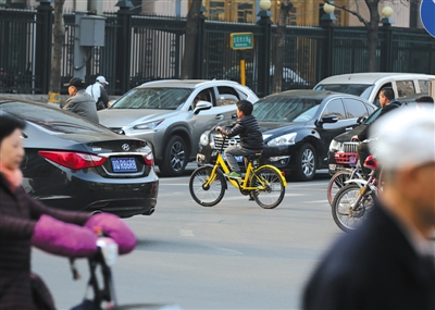 3月29日，东城区东花市大街，一个小孩骑着共享单车穿越街道。新京报记者 王飞 摄