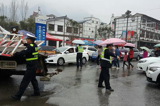 昨天陕西丹凤降下小雨，交警在雨中疏导交通。（图片来源：@丹凤交警Stone）