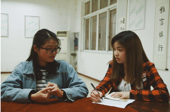 在采访汉马志愿者刘洁时做着笔记的大学生记者