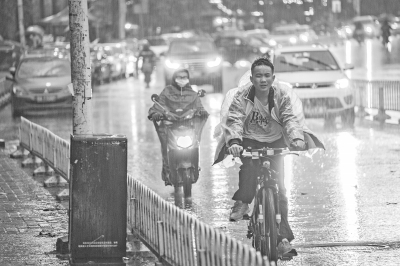 昨天傍晚，光谷珞雄路雨中骑行的少年    记者周迪 摄