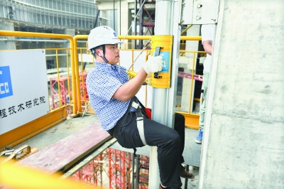 体重80公斤的试验人员利用依附于建筑外墙的逃生轨道,从高楼40米处以1.5米/秒的速度下降,用时26秒安全落地 记者胡冬冬 摄