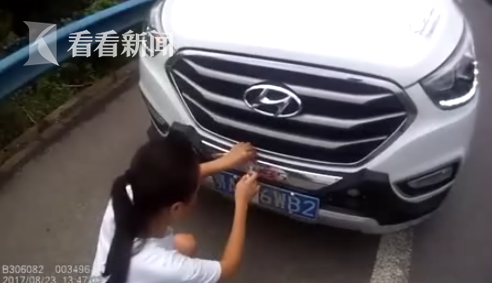這位妹紙遮號牌太專心，被身后警察嚇到跳起