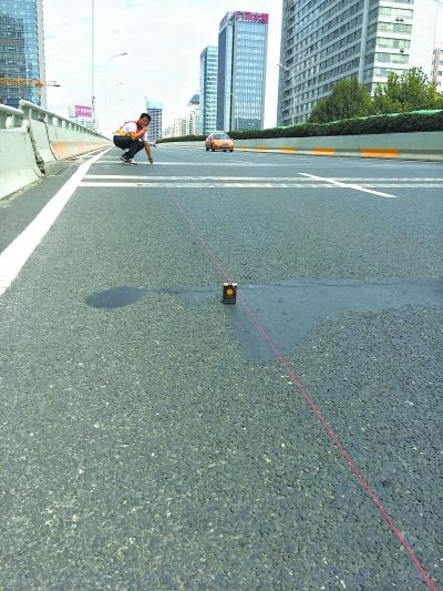 徐东高架桥“跳车”处,技术人员测量面积和跳台落差高度。