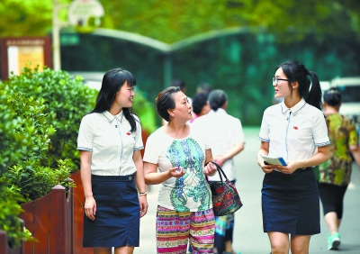 黄埔人家小区,杨炯毅(左)、靳爽爽(右)同散步回来的居民周梦书(中)拉家常