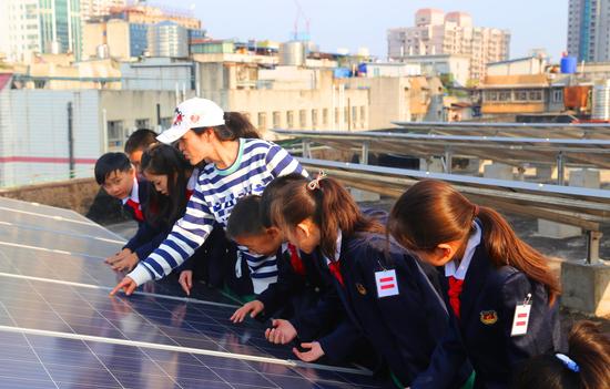 老师给学生讲解太阳能发电相关环保知识