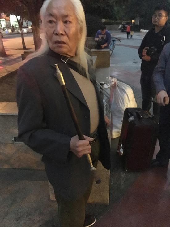 在成都自家小區(qū)門口逗留的黃云彪，當晚他沒有回家，在兩名男子陪同下入住附近一家賓館。澎湃新聞記者 王萬春 圖