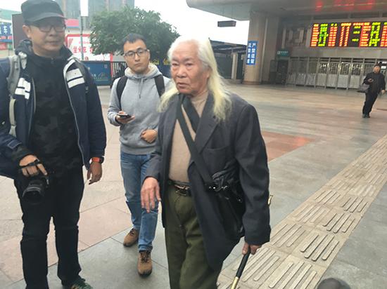 黃云彪手持煙槍，他稱寶劍已送給了王鴻達(dá)，圖為媒體記者們試圖采訪黃云彪。澎湃新聞記者 王萬春 圖